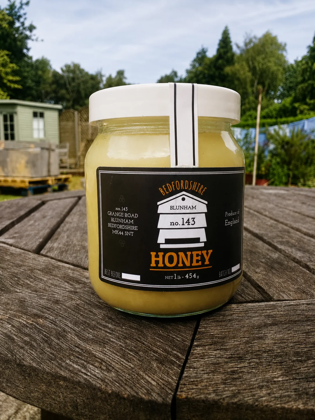 A jar of no.143 Bedfordshire honey in the apiary garden